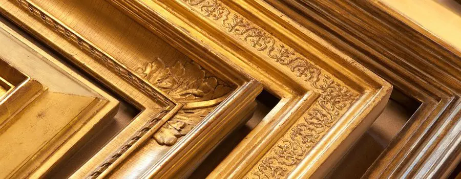 A close up of the gold frame on a wall