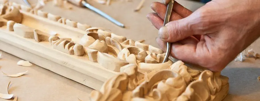 A person carving wood with a knife and fork.