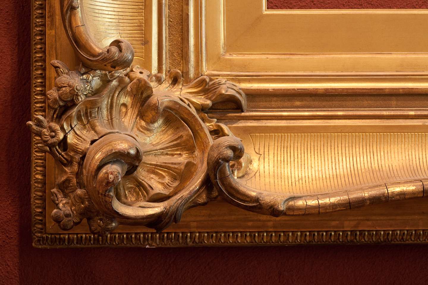 A gold frame with a large ornate design on it.