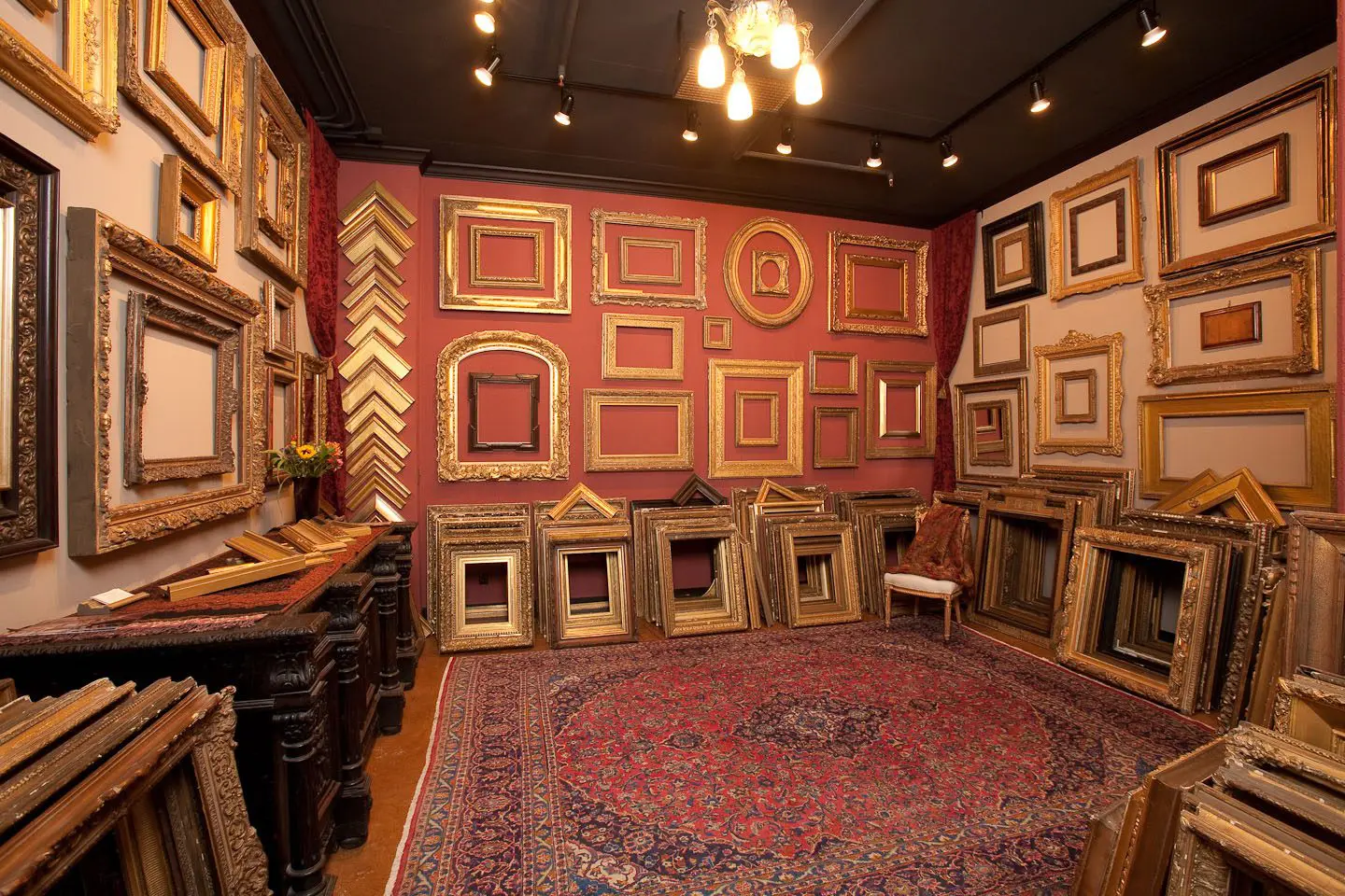 A room filled with lots of frames and rugs.