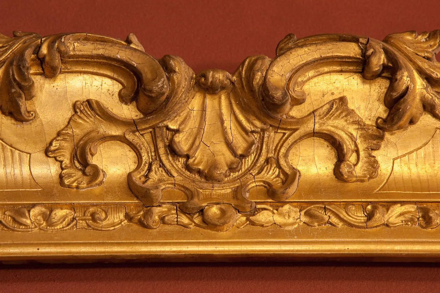 A gold frame with a large ornate design.