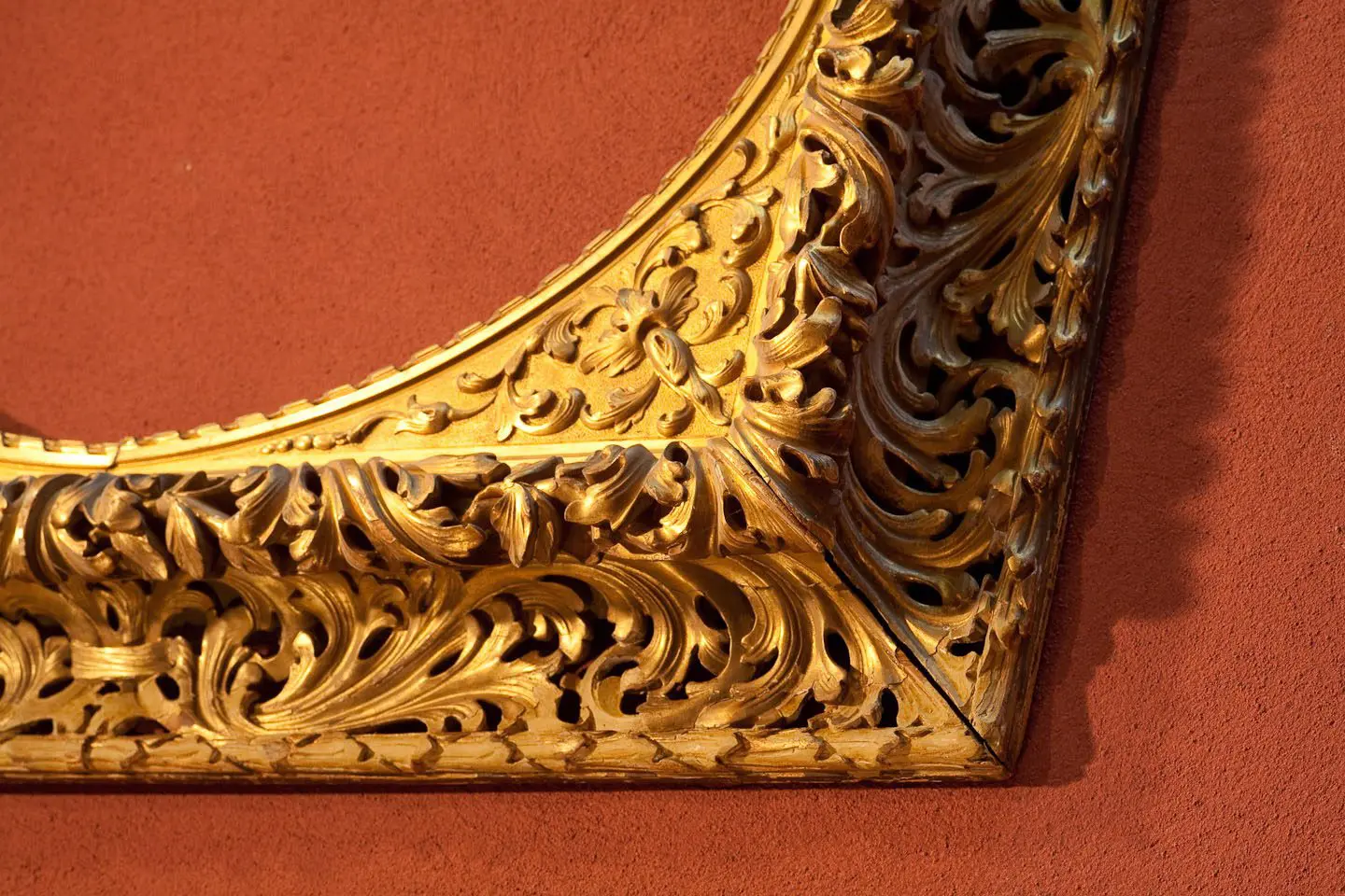 A gold frame with intricate designs on the side of it.