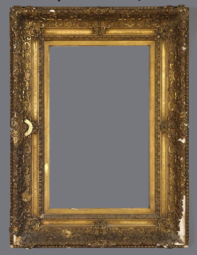 A large gold frame with ornate carvings and a gray background.