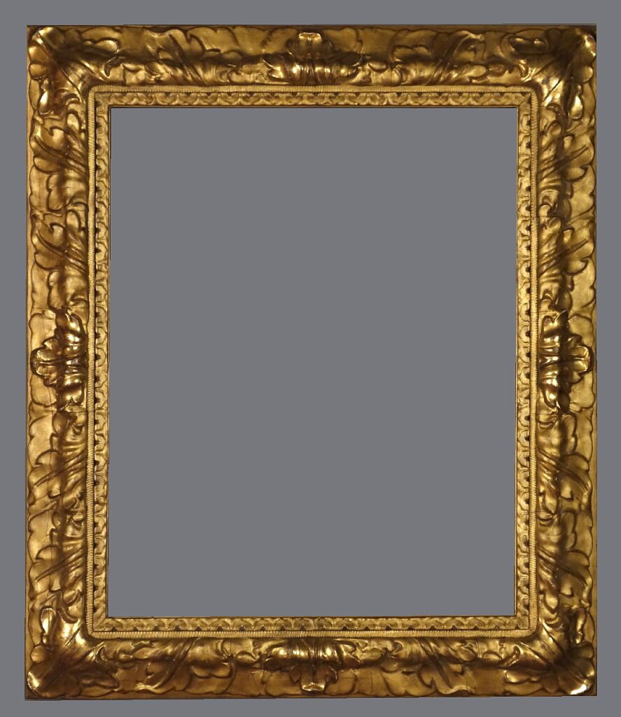 A picture frame with gold leaf and an ornate design.