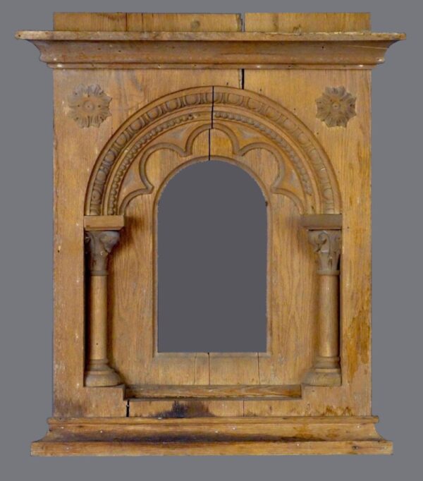 A wooden cabinet with a mirror and two pillars.