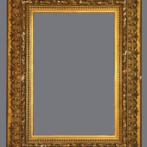 A picture frame with gold leaf and ornate design.