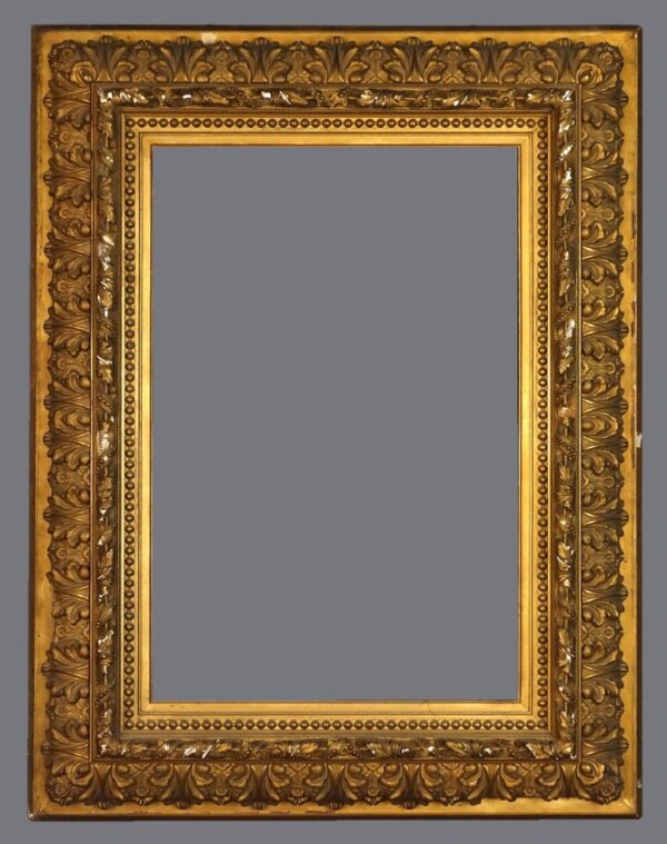 A picture frame with gold leaf and ornate design.