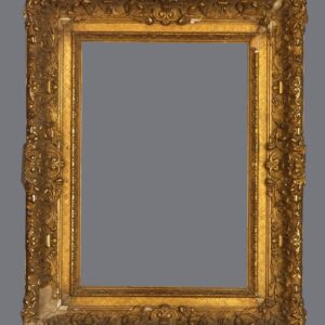 A picture frame with gold leaf and ornate design.