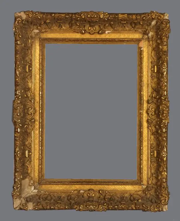 A picture frame with gold leaf and ornate design.