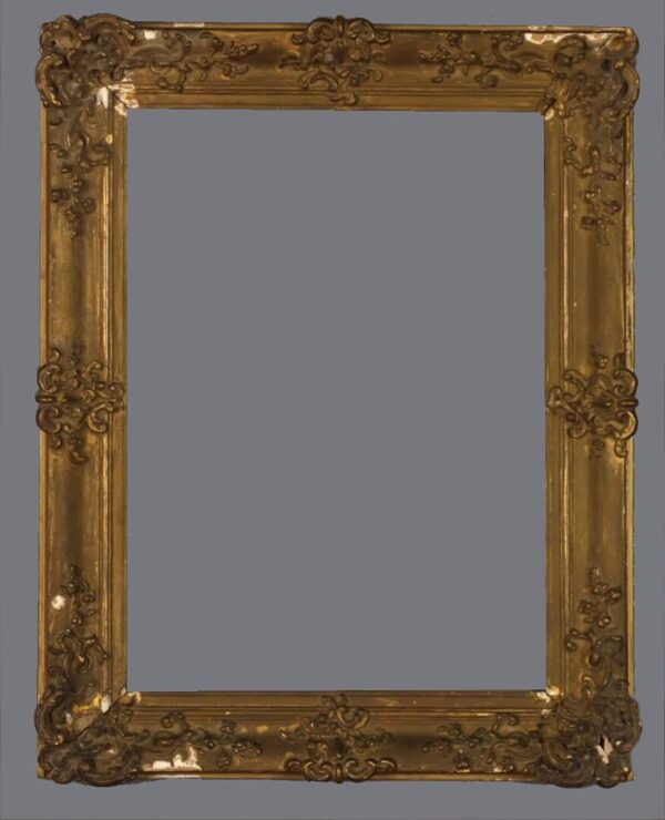 A picture frame with gold leaf and ornate design.