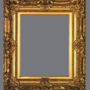 A picture frame with gold leaf and ornate design.