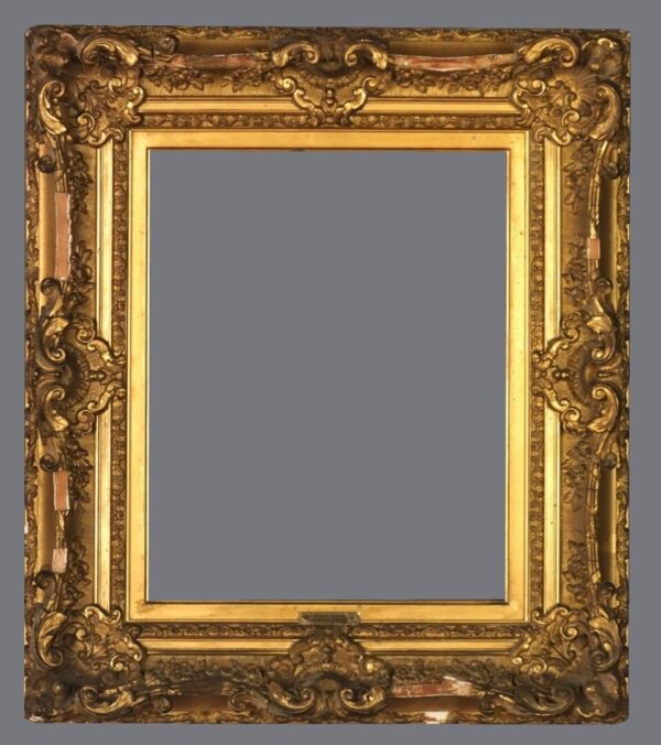 A picture frame with gold leaf and ornate design.