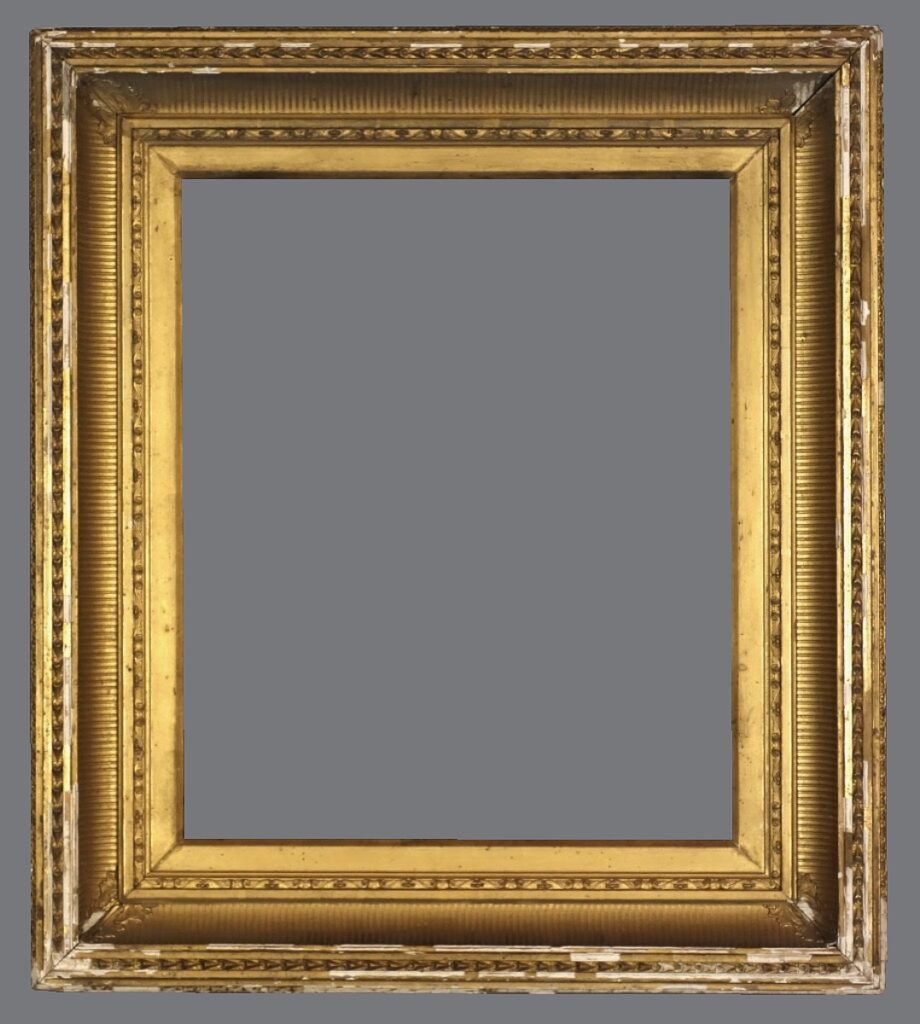 A picture frame with gold leaf and an ornate design.