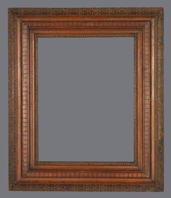 A picture frame with an ornate wood border.