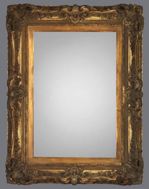 A mirror with gold frame and a gray background