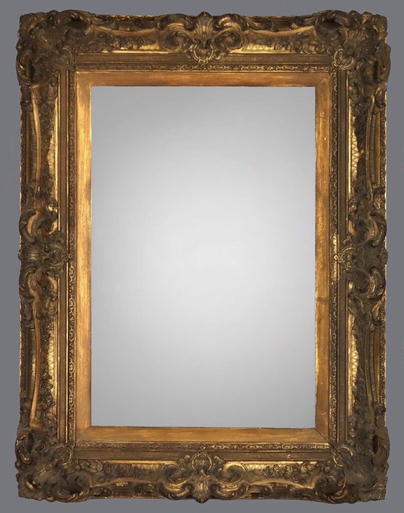 A mirror with gold frame and a gray background