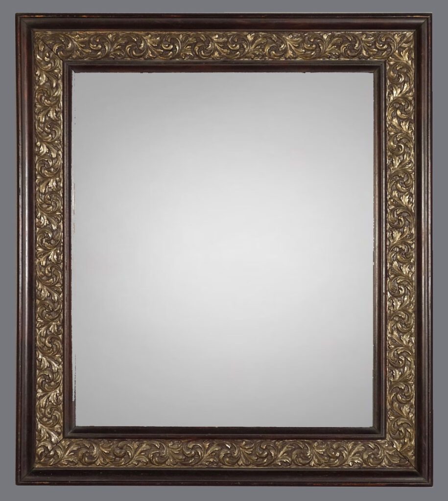 A mirror with gold leaf frame and white background.