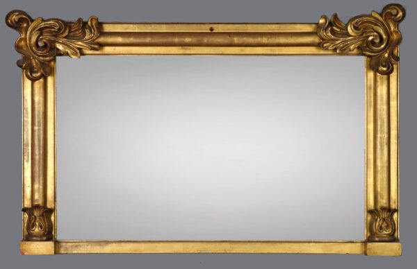 A gold mirror with two large wooden frames.