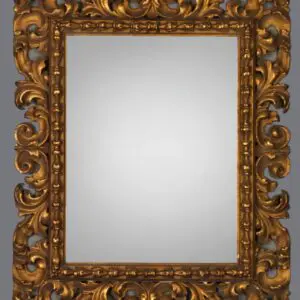 A gold framed mirror with ornate design on the front.