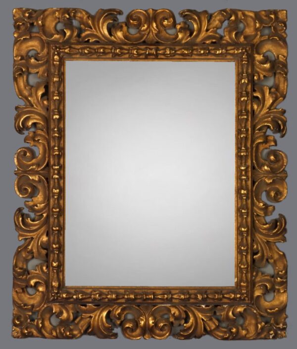 A gold framed mirror with ornate design on the front.