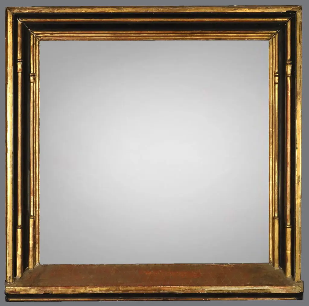 A mirror with gold frame and gray background