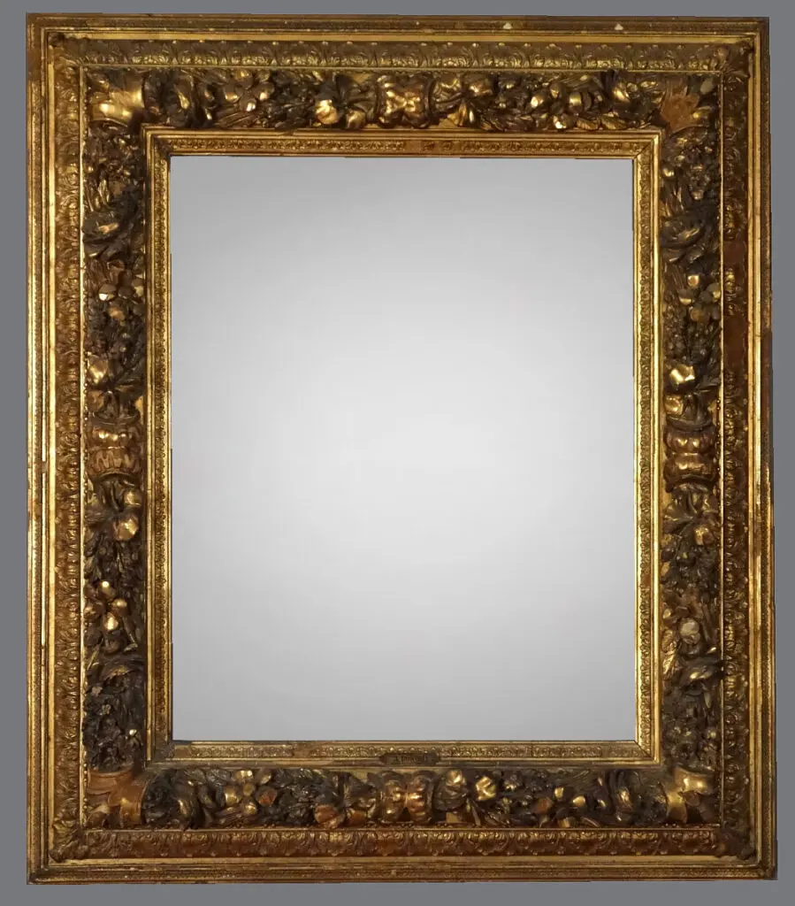 A mirror with gold frame and floral design.