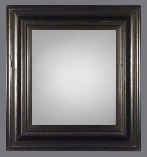 A mirror with a black frame on the wall.