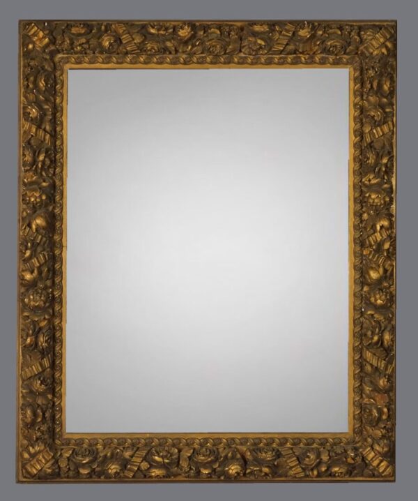 A mirror with gold frame and gray background