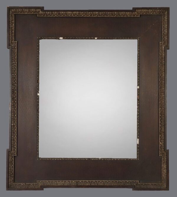 A mirror with a wooden frame and metal trim.