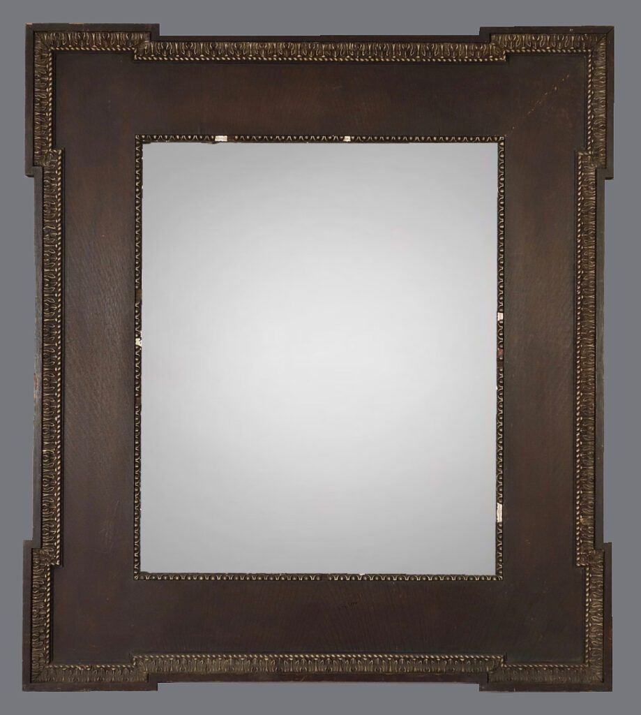 A mirror with a wooden frame and metal trim.