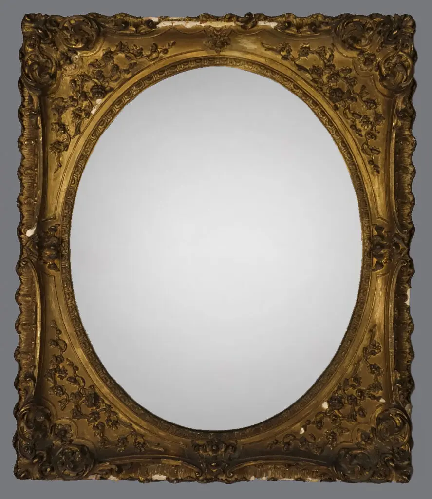 A gold mirror with a decorative frame.