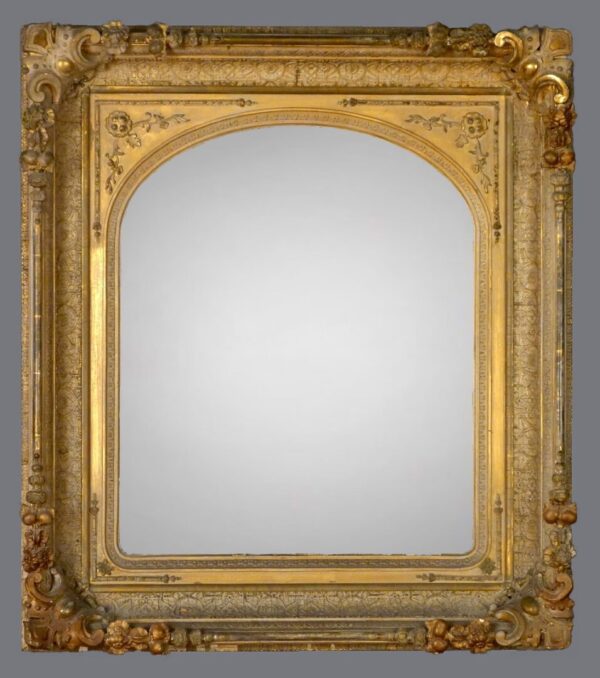 A gold frame with a mirror on the side.