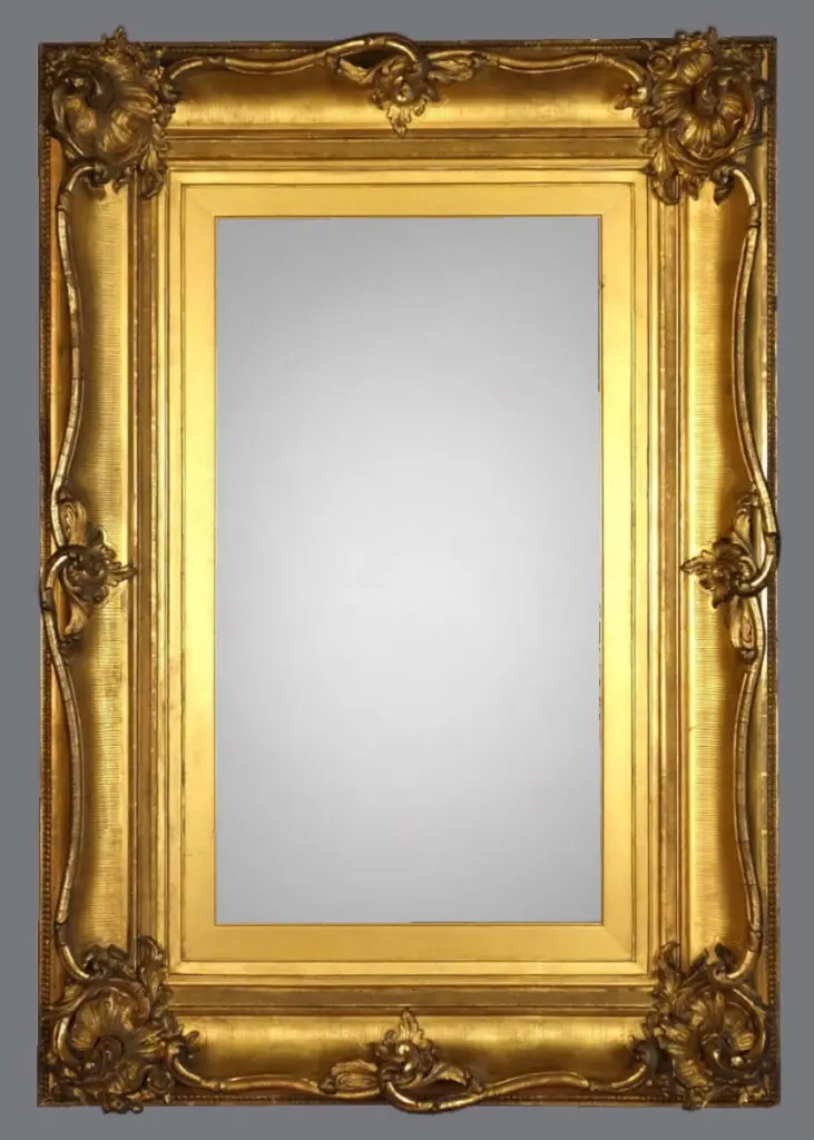 A gold framed mirror with a gray background