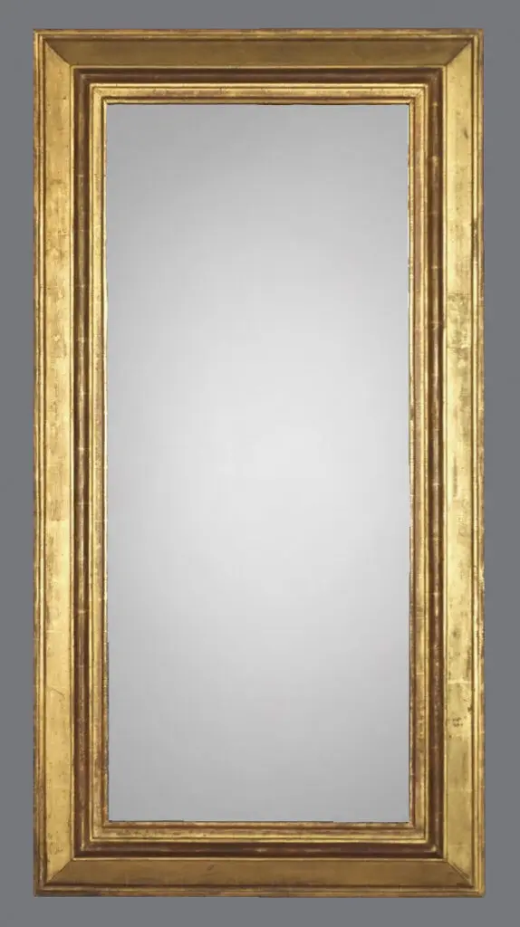 A large gold mirror with a wooden frame.