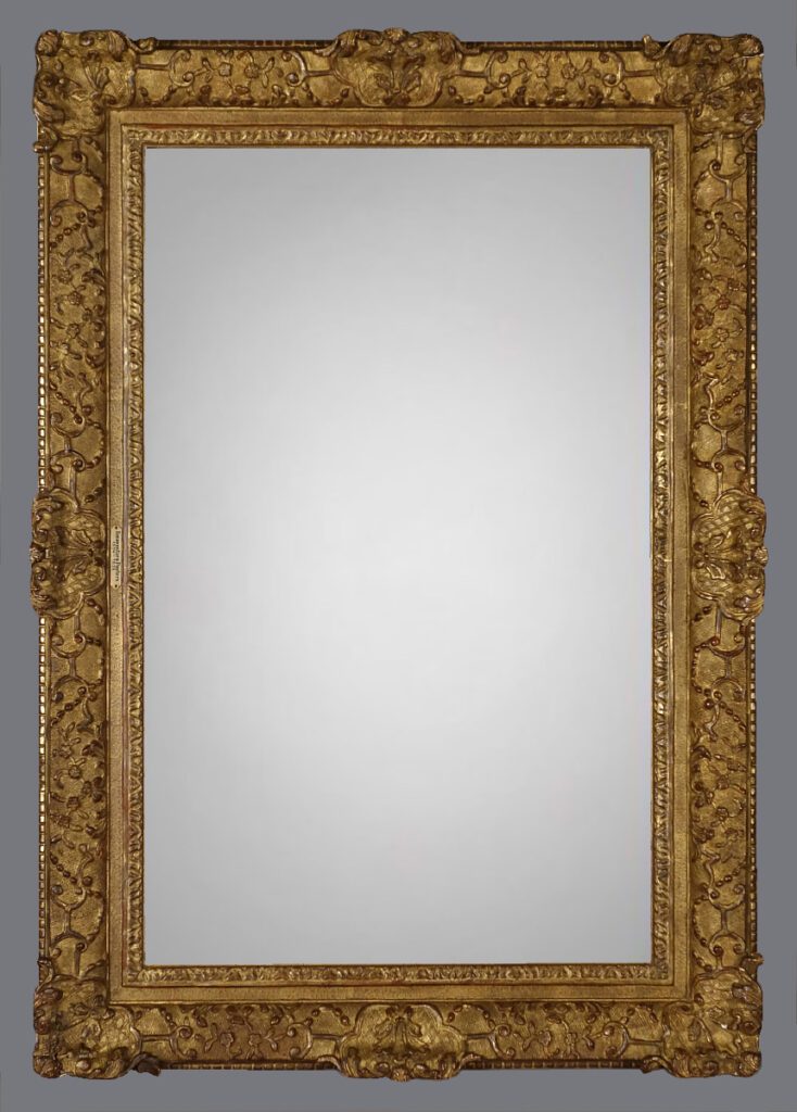 A large gold mirror with ornate frame and design.