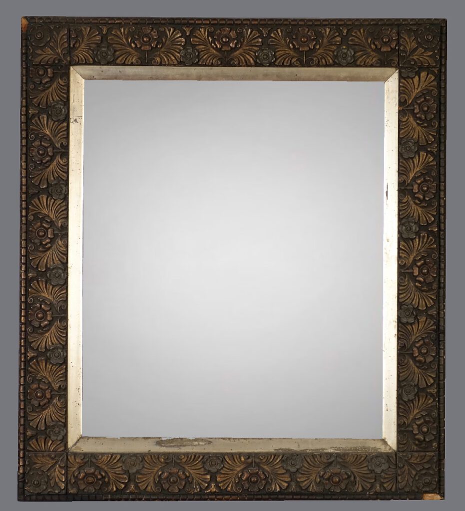 A mirror with a gold frame and a black border.