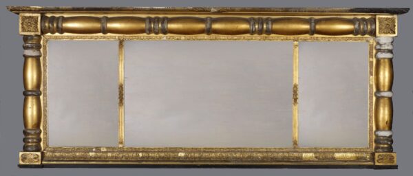 A gold mirror with a wooden frame and a black border.