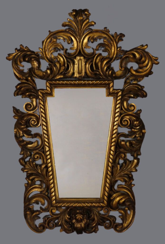 A gold mirror with ornate design and an intricate frame.